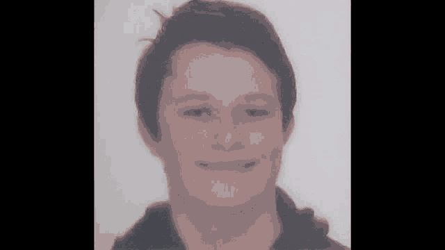 a close up of a young man 's face with a smile on his face