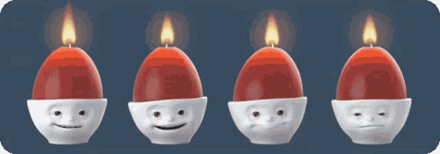 four candles with different faces on them are lit up