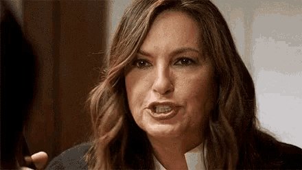 a woman with long brown hair is making a funny face .