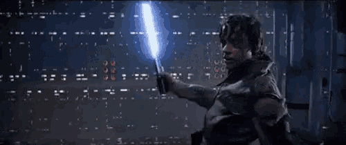 a person is holding a red and blue light saber in their hand .