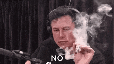 elon musk is smoking a cigarette in front of a microphone in a studio .