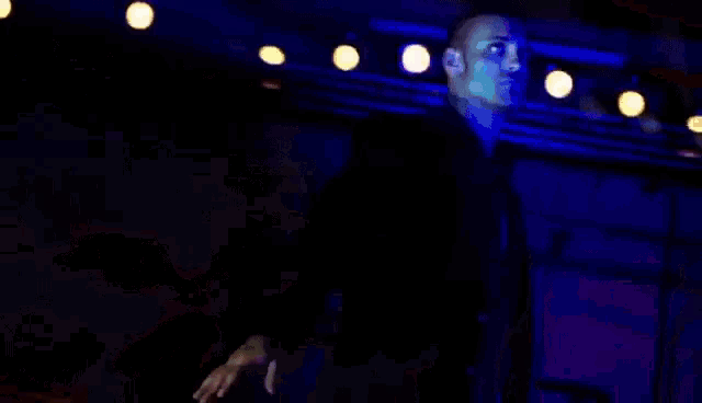 a man in a suit and tie is standing in front of a stage .