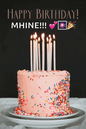 a pink birthday cake with candles and sprinkles and the words happy birthday mhine