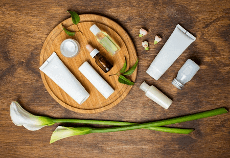 a wooden tray with various bottles and tubes of cosmetics on it