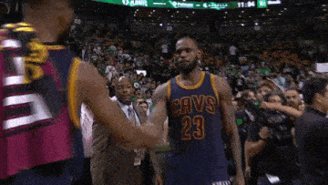 two basketball players are giving each other a high five in front of a crowd