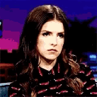 a woman is making a funny face while sitting in front of a camera .