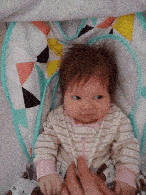 a baby is smiling while sitting in a chair