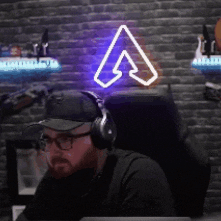 a man wearing headphones is sitting in a chair in front of a neon sign .