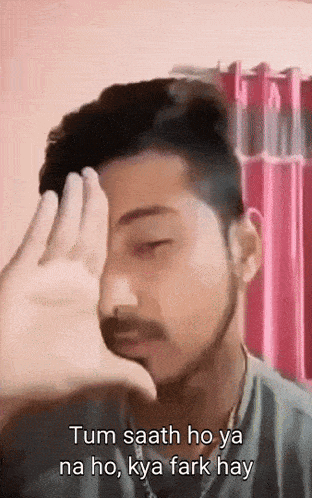 a man covering his face with his hand and the words tum saath ho ya na ho , kya fark hay
