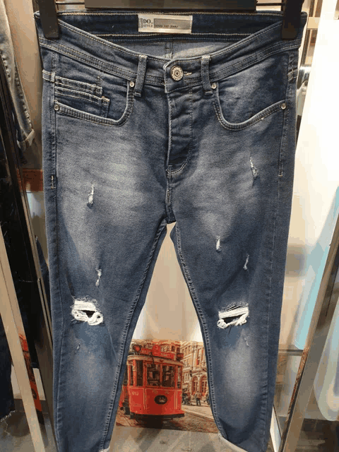 a pair of blue jeans with holes in them are on a hanger