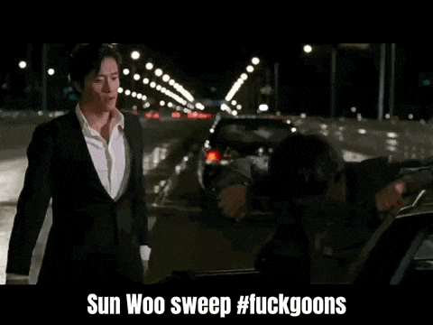 a man in a suit is talking to another man in a car on a highway at night .