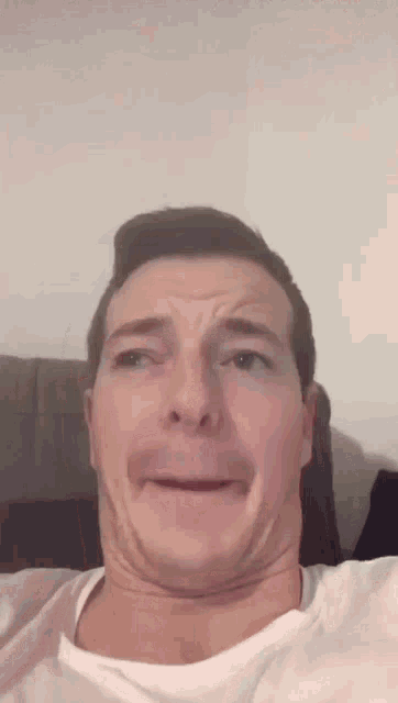 a man in a white shirt makes a funny face