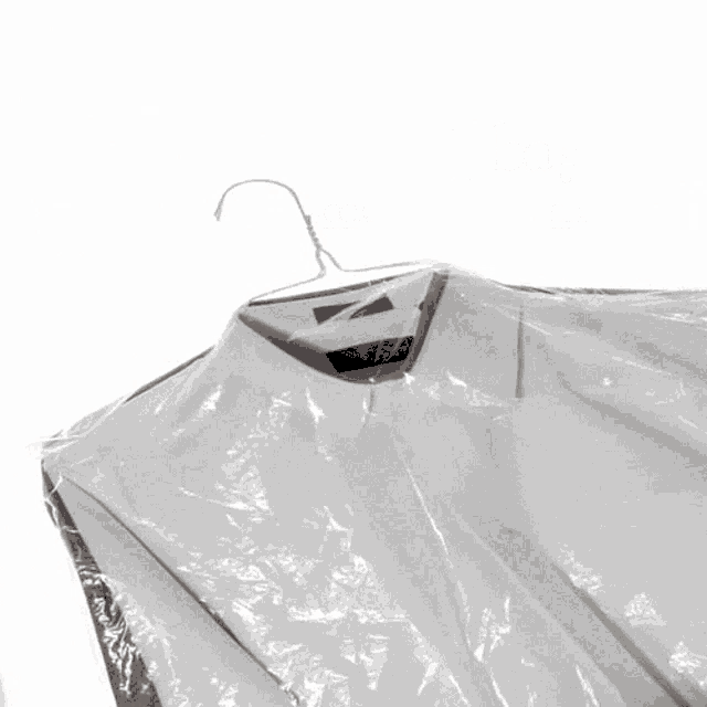 a shirt is wrapped in plastic and hanging on a hanger with the word egrac behind it