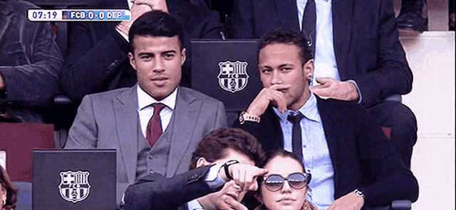 a group of people sitting in a stadium with a fcb logo on their seat