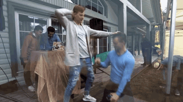 a man in a blue sweater is dancing in front of a sign that says ' finland '