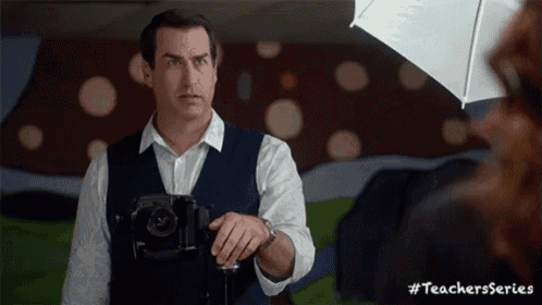 a man is holding a camera in front of a white umbrella with the hashtag #teachersseries