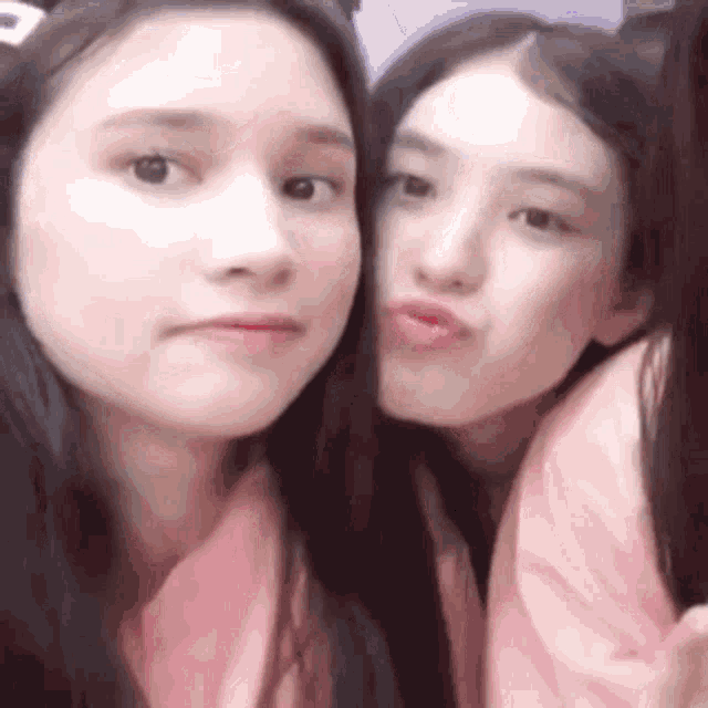 two young women are posing for a picture together .