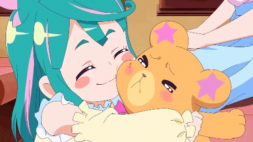 a girl is hugging a teddy bear with a pink star on it