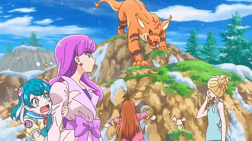 a group of girls are standing on top of a hill looking at a dinosaur