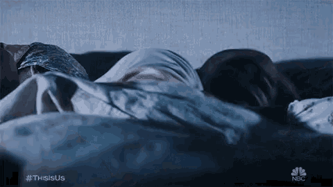 a man and a woman are sleeping in a bed together at night .
