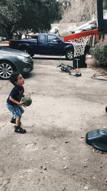 a young boy playing basketball with a watermelon in his hand