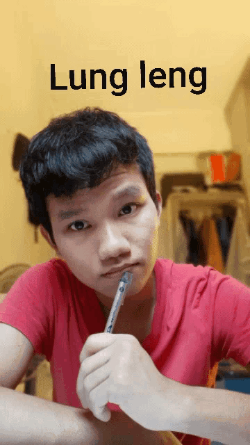 a man in a red shirt is holding a pen in his mouth and the word lung leng is above him
