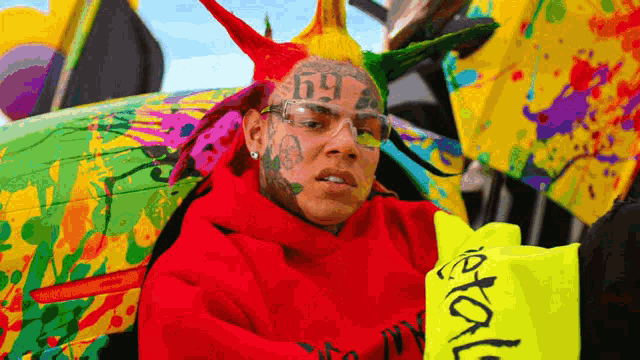 a man wearing a red hoodie with the number 69 on his head