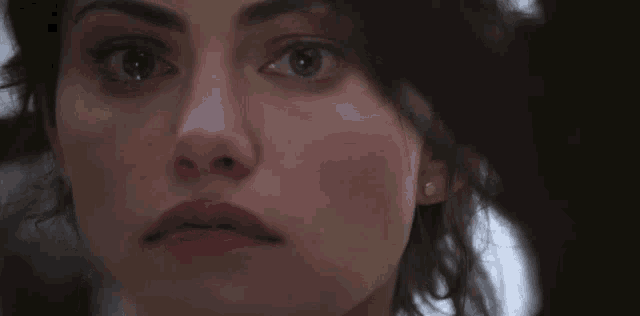 a close up of a woman 's face looking at the camera