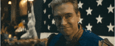 a man is sitting in front of an american flag with the words " a oy bla " written on it