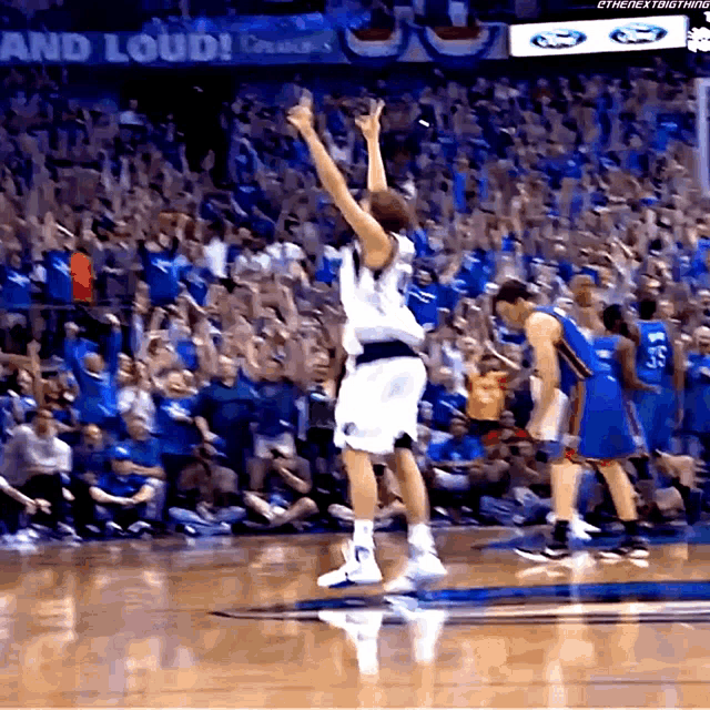 a basketball game is being played in front of a crowd with a sign that says " and loud "