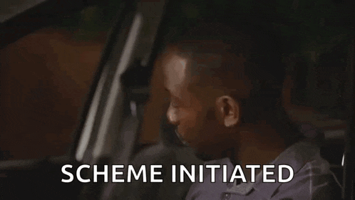 a man is sitting in the back seat of a car with the words scheme initiated behind him .