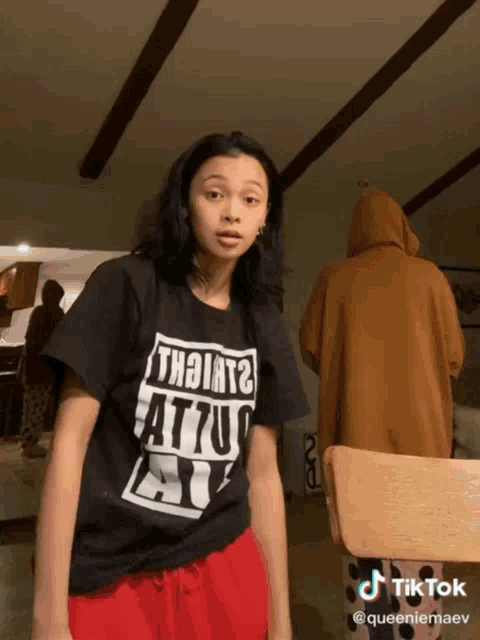 a girl wearing a black t-shirt that says " th9iat2 " on it
