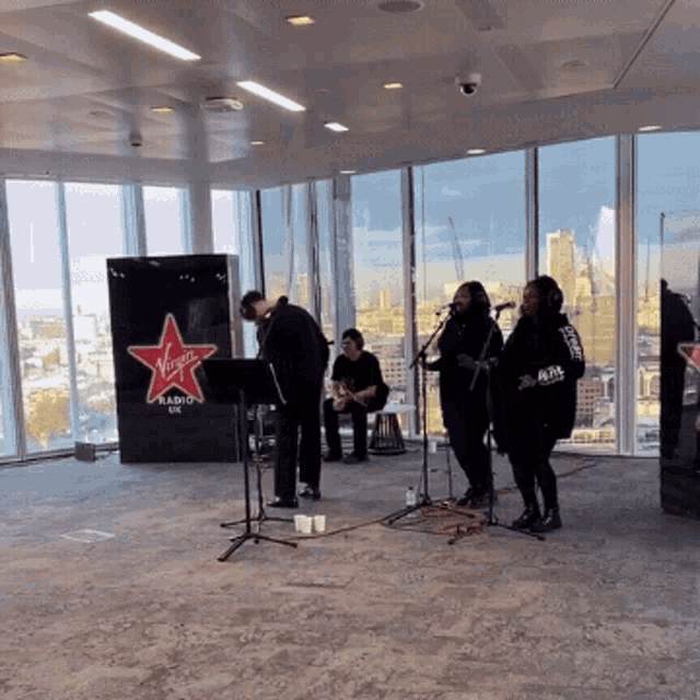 a group of people are playing music in front of a virgin radio sign