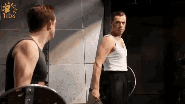 a man is standing in front of a mirror holding a shield and looking at himself .