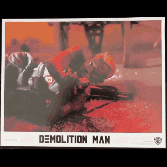 a poster for the movie demolition man with a man laying on the floor