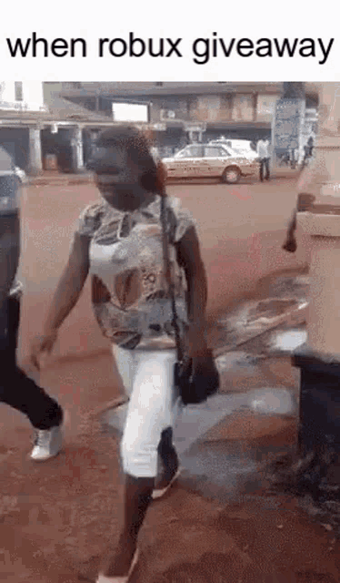 a woman is walking down a street while a man stands behind her .