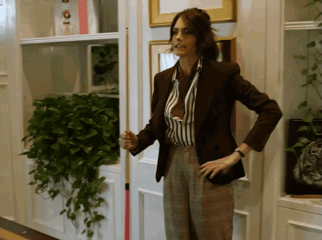 a woman in a brown jacket holds a pool cue in her hand