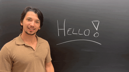 a man is standing in front of a blackboard that says hello