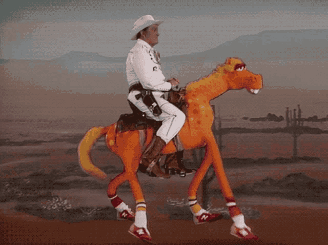 a man in a cowboy hat is riding on the back of an orange toy horse