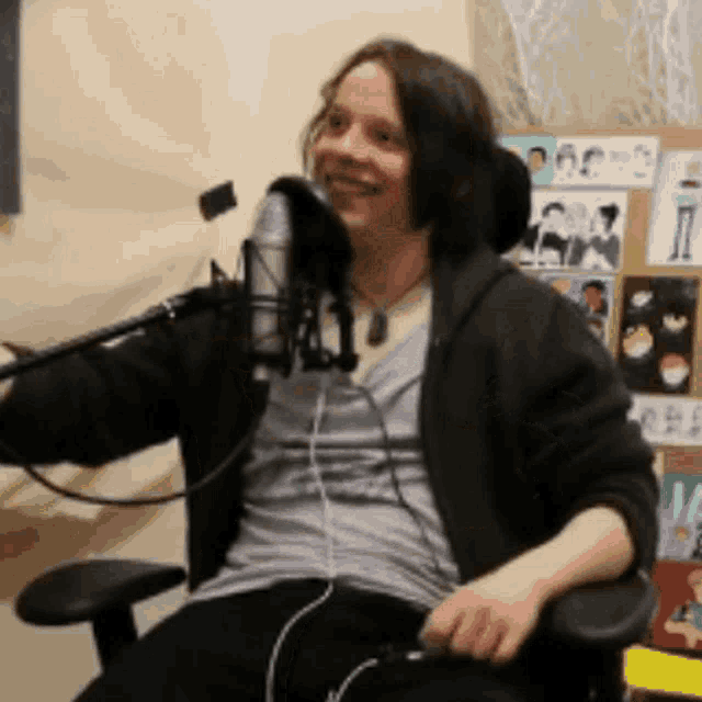 a man in a wheelchair is sitting in front of a microphone and smiling