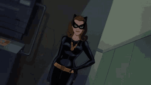 three women in catwoman costumes are standing next to each other in a hallway .