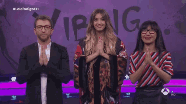 a man and two women are standing in front of a purple background with the word vibang written on it