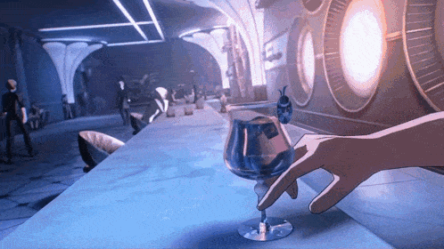 a hand is holding a glass of liquid in a room