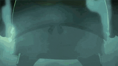 a person is standing in a dark room with smoke coming out of their mouth .