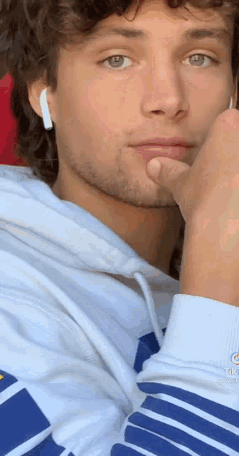 a close up of a man wearing headphones and a hoodie