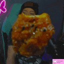 a person is holding a piece of food in front of their face