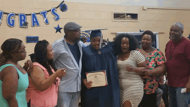 a group of people standing in front of a sign that says ' congrats ' on it