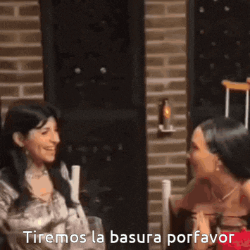 two women are sitting at a table and one of them is saying tiremos la basura porfavor