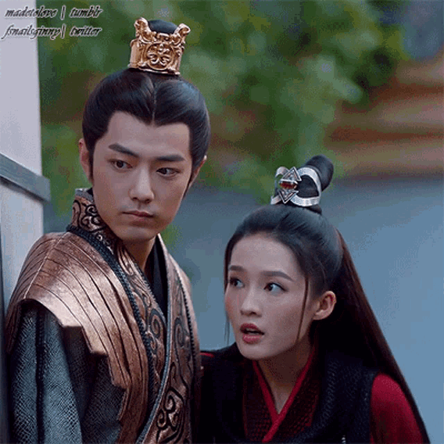 a man and a woman are standing next to each other with a crown on their head ..