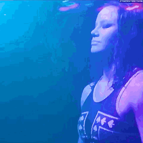 a woman with long blonde hair is standing in front of a blue and purple background